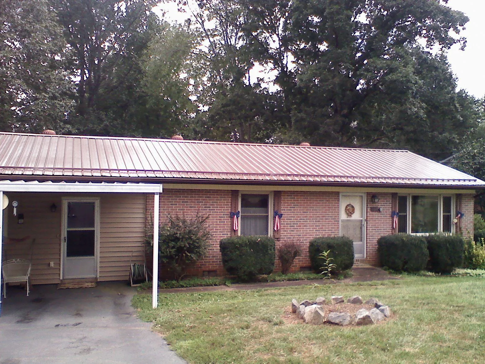 Bronze metal roof and carport on a brick ranch home — Roof Repair work by our crew in Waynesboro